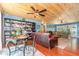 Open living room featuring a wood-planked ceiling, a table and chairs, and a large bookcase at 2518 Fort Lane Rd, Geneva, FL 32732
