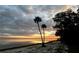 Scenic waterfront view featuring palm trees silhouetted against a breathtaking sunset sky at 2518 Fort Lane Rd, Geneva, FL 32732