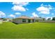 Expansive backyard featuring lush green grass and an inviting view of the home's exterior at 2668 Grand Central Ave, Tavares, FL 32778