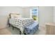 Cozy bedroom features bed with patterned bedding and blue upholstered bench at 2668 Grand Central Ave, Tavares, FL 32778