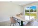 Bright dining room with a modern marble table and plush chairs, offering backyard views at 2668 Grand Central Ave, Tavares, FL 32778