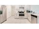 Well-lit kitchen featuring stainless steel appliances, white cabinets, and tiled flooring at 2668 Grand Central Ave, Tavares, FL 32778
