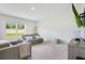 Bright living room with a comfortable sofa, neutral-toned carpet, and a view through a large window at 2668 Grand Central Ave, Tavares, FL 32778