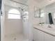 Bright bathroom featuring a shower with white tile and arched window, with modern vanity at 2729 N Poinciana Blvd # 125, Kissimmee, FL 34746