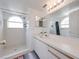 Bright bathroom featuring white tiled shower, arched window, and vanity with generous counter space at 2729 N Poinciana Blvd # 125, Kissimmee, FL 34746