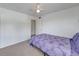 Cozy bedroom featuring a ceiling fan, neutral carpet, and a comfortable bed with purple floral bedding at 2729 N Poinciana Blvd # 125, Kissimmee, FL 34746