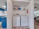 Well-organized laundry closet with washer, dryer, and storage shelf, located near the kitchen and bedroom at 2729 N Poinciana Blvd # 125, Kissimmee, FL 34746
