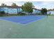 Well-maintained blue and green tennis court surrounded by trees and blue residential buildings at 2729 N Poinciana Blvd # 125, Kissimmee, FL 34746