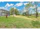 Large grassy backyard with a screened-in patio and a storage shed at 2772 Pelham Cir, Deltona, FL 32738
