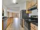 Modern kitchen boasting stainless steel appliances, ample counter space, and wooden cabinets for an organized cooking area at 2772 Pelham Cir, Deltona, FL 32738