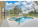 Sparkling pool and spa inside screened enclosure with blue skies overhead at 2772 Pelham Cir, Deltona, FL 32738