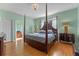 Main bedroom with four-poster bed, ensuite bathroom, and hardwood floors at 2828 Northampton Ave, Orlando, FL 32828