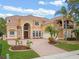 Stunning two-story Mediterranean home featuring a tile roof, arched entryway, and lush landscaping at 2828 Northampton Ave, Orlando, FL 32828