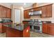 Gourmet kitchen featuring stainless steel appliances, custom wood cabinetry, an island, and granite countertops at 2828 Northampton Ave, Orlando, FL 32828