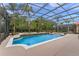 Wide view of a screened in pool area with tropical landscaping and water features at 2828 Northampton Ave, Orlando, FL 32828