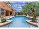 Relaxing backyard pool area featuring a screened enclosure, tropical landscaping, and an outdoor seating area at 2828 Northampton Ave, Orlando, FL 32828