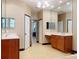 Bright bathroom featuring dual sinks, a large mirror, and a doorway to another room at 3216 Rolling Hills Ln, Apopka, FL 32712