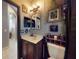 Quaint bathroom design with custom wall art, dark wood vanity, and decorative hanging plants adds to the ambiance at 3216 Rolling Hills Ln, Apopka, FL 32712