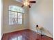 Bedroom with hardwood floors, ceiling fan, and arched window at 3216 Rolling Hills Ln, Apopka, FL 32712
