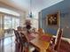 Dining room with a dark wood table, seating for six, and sliding glass doors to the screened in lanai at 3216 Rolling Hills Ln, Apopka, FL 32712