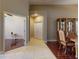 View of the entryway with ceramic tile floors, dark wood floors in the living room, and an arched doorway with white doors at 3216 Rolling Hills Ln, Apopka, FL 32712