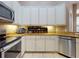 Kitchen boasts granite countertops, stainless steel appliances, white cabinetry, and a tile backsplash at 3216 Rolling Hills Ln, Apopka, FL 32712