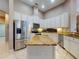 Kitchen features stainless steel appliances, a center island with granite countertops, and white cabinets at 3216 Rolling Hills Ln, Apopka, FL 32712