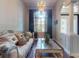 Charming living room with plush furniture, chandelier lighting, dark wood floors, and large window with sheer drapes at 3216 Rolling Hills Ln, Apopka, FL 32712