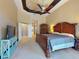 Main bedroom featuring tray ceiling, ceiling fan, carpeted floors, and a large bed at 3216 Rolling Hills Ln, Apopka, FL 32712