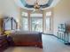 Main bedroom featuring tray ceilings, ceiling fan, carpeted floors and expansive windows at 3216 Rolling Hills Ln, Apopka, FL 32712