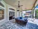 Inviting outdoor living space featuring stone flooring, comfortable patio seating, ceiling fans, and a tranquil backyard view at 3216 Rolling Hills Ln, Apopka, FL 32712