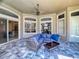 Stylish outdoor patio showcasing a wicker sofa, glass table, and seamless transition to interior spaces with ample natural light at 3216 Rolling Hills Ln, Apopka, FL 32712