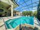 A gorgeous screened-in pool with an attached spa, elegant lighting, and an expansive outdoor living space at 3216 Rolling Hills Ln, Apopka, FL 32712