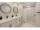 Well-lit bathroom with double vanity, sleek black fixtures, and a shower featuring elegant marble-look tile at 3325 W Washington St, Orlando, FL 32805