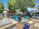 Relaxing backyard with a fire pit, outdoor kitchen, mature trees, and cozy seating, creating a private retreat at 3443 Arnel Dr, Winter Park, FL 32792