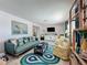 Bright living room featuring a modern sofa, patterned chairs, and a stylish blue rug at 3443 Arnel Dr, Winter Park, FL 32792