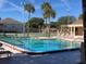 Community pool with lounge seating, palm trees and clear blue water at 510 Cranes Way # 302, Altamonte Springs, FL 32701