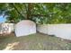 White storage shed and manicured garden near the white fence in this home's backyard at 5113 Mystic Point Ct, Orlando, FL 32812
