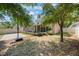 Picturesque backyard with a basketball court, covered patio, and lush green trees at 5113 Mystic Point Ct, Orlando, FL 32812