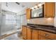 Bathroom featuring granite countertops, wood cabinetry, and a tile shower with glass block window at 5113 Mystic Point Ct, Orlando, FL 32812