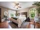 Bright bedroom with wood floors, a king bed, and a view of the well-maintained exterior at 5113 Mystic Point Ct, Orlando, FL 32812