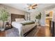 Bright bedroom featuring a ceiling fan, a king bed, wood flooring, and view into the ensuite bathroom at 5113 Mystic Point Ct, Orlando, FL 32812