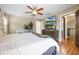 Bright bedroom features a ceiling fan, a king bed, wood floors, and television with decorative fireplace beneath at 5113 Mystic Point Ct, Orlando, FL 32812