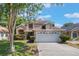 Charming two-story home features a well-maintained lawn, mature trees, and an attached two-car garage at 5113 Mystic Point Ct, Orlando, FL 32812