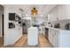 Spacious kitchen with white cabinets, stainless appliances, island, and wood floors offers ample space at 5113 Mystic Point Ct, Orlando, FL 32812