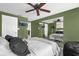 The bedroom has bright green walls, a ceiling fan, and a mirror reflecting the rest of the room at 5575 Garden Grove Cir, Winter Park, FL 32792