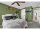 This bedroom features bright green walls, a ceiling fan, a TV, and a large bed at 5575 Garden Grove Cir, Winter Park, FL 32792