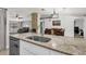 Bright kitchen with granite countertops, a stainless steel dishwasher, and views into the dining and living spaces at 5575 Garden Grove Cir, Winter Park, FL 32792