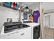 Well-equipped laundry room with modern washer, dryer, and storage shelves at 5575 Garden Grove Cir, Winter Park, FL 32792