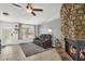 Cozy living room featuring a stone fireplace, comfortable seating, and natural light from a large window at 5575 Garden Grove Cir, Winter Park, FL 32792